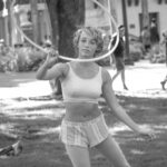 woman in white sports bra and shorts holding hoop